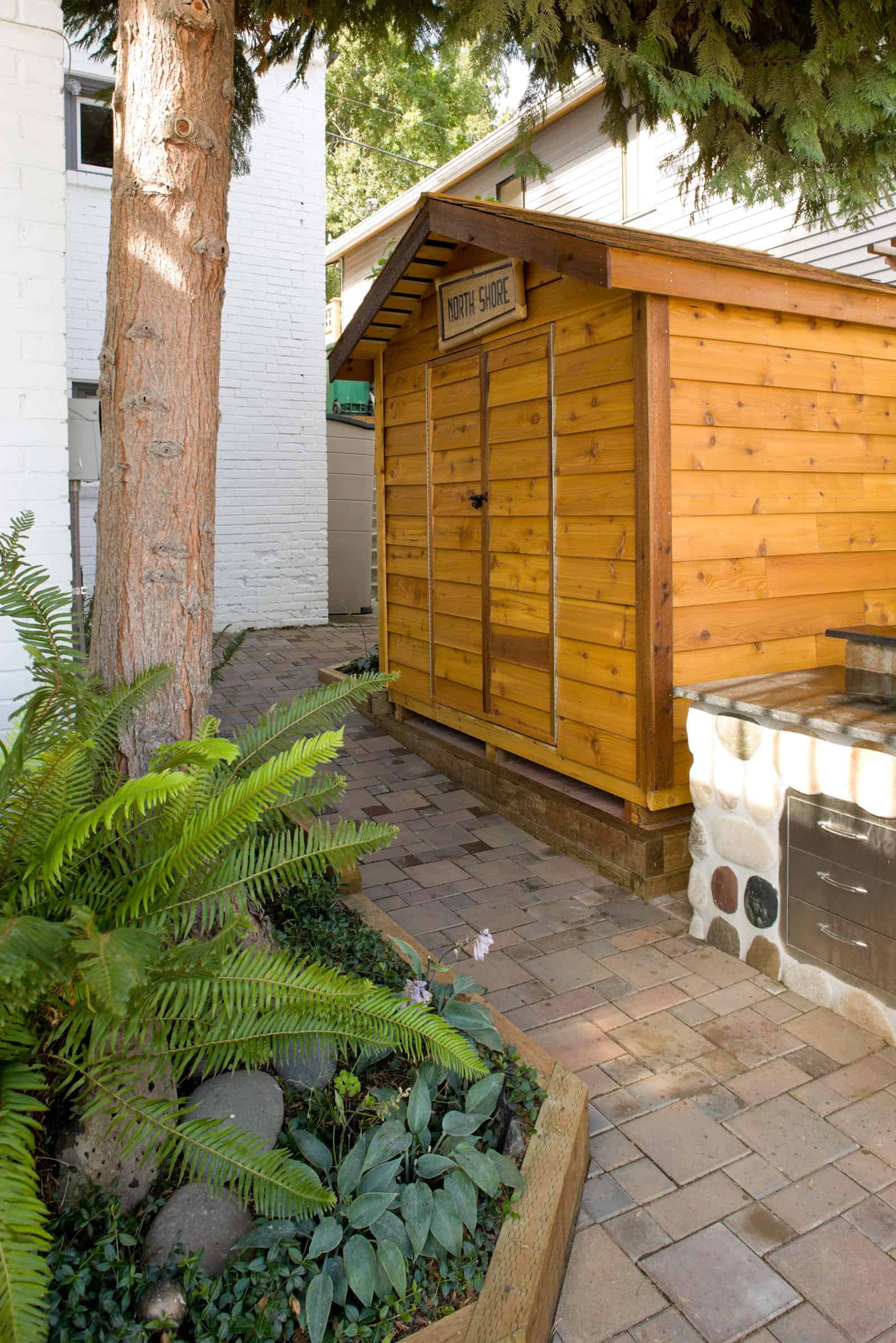 Landscape architecture with brick pathway, custom made wood shed and stone grill